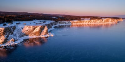 Les Chalets Nautika Gaspésie au bord de l'eau en hiver.