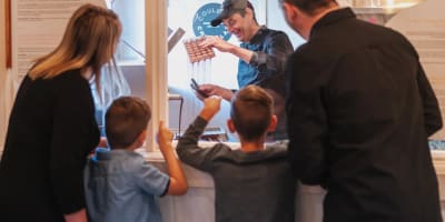 Family watching a chocolatier at work.