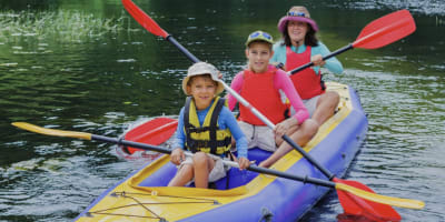 Family kayaking on an inflatable kayak on a river.