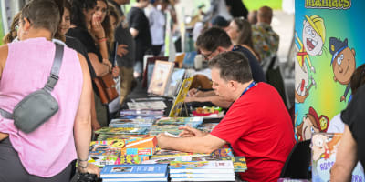 Festival de la BD de Prévost - Des bédéistes assis à des tables rencontrent des personnes