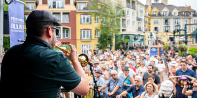 Trumpet player on stage and the crowd watching him.