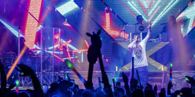 Riverside Festival - Artist on stage at an electro concert, with animated crowd and colored lights.