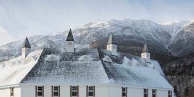 The Gîte du Mont-Albert in winter, with a mountain in the background.