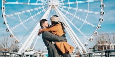 Couple in front of Grande Roue of Montreal.