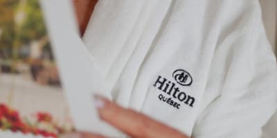A woman wearing a Hilton bathrobe.