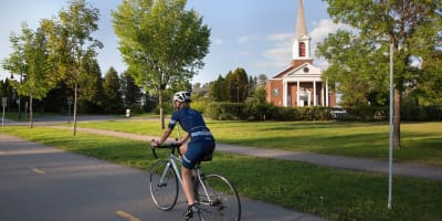 Personne en vélo devant l'hôtel Le Sainte-Crème.