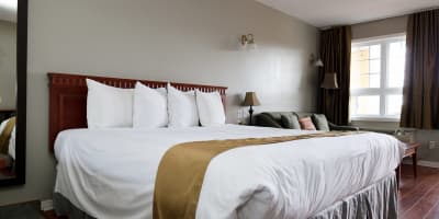 Room with king bed and sofa at Hotel & Suites Les Laurentides.