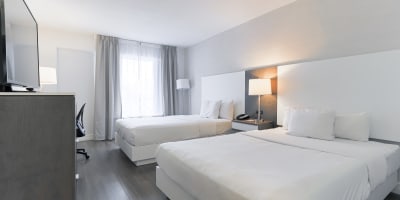 A room with two double beds at Hôtel Universel Québec.