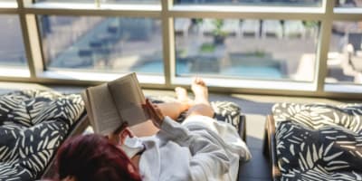 Hôtel Universel Rivière-du-Loup - A person is lying down and reading a book