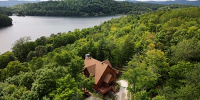 Vue aérienne d'un chalet près d'un lac en été.