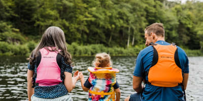 Kenauk Nature -  Two adults and a child on the edge of a quay, wearing life jackets