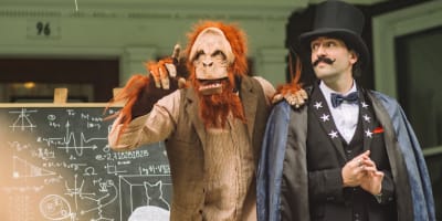 La Grande Échappée - A person dressed as a magician accompanied by a person dressed as a monkey.