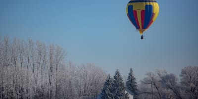 Hot air balloon flight in a winter landscape.