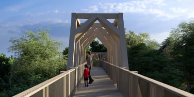 A child and a parent on a footbridge at La Place des Sommets.