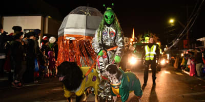 Femme costumée en extra-terrestre et 2 chiens costumés.