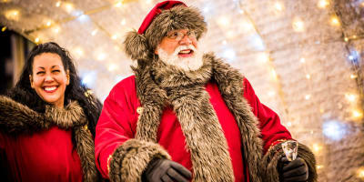 Santa Claus walking through an illuminated passage.