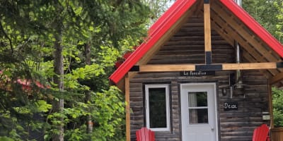 Micro-Chalets des Appalaches - Small cabin with two red chairs on the deck