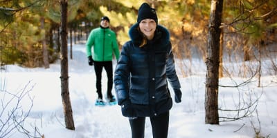 Couple playing snowshoeing in winter at Moulin des Pionniers.