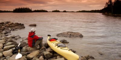 Kayaker on the shore of a lake in Aiguebelle National Park.