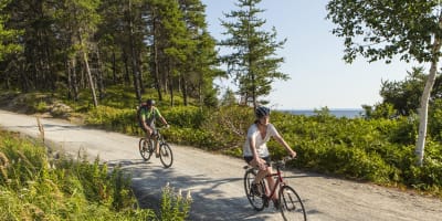 Parc national de la Pointe-Taillon - A man and a woman cycling in nature
