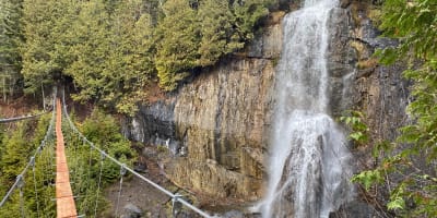 Floating bridge in front of waterfalls: Parcours Aventures - Via ferrata Gaspésie.
