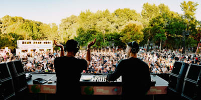 Two DJs on stage in front of the crowd.