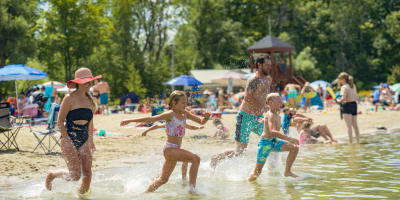 Famille courant dans l'eau à la plage.