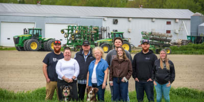 Famille de la Ferme Agrikel devant la ferme et tracteurs.