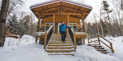 Homme devant un chalet.