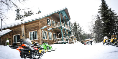 Snowmobiles next to the Pourvoirie Lac Dumoulin lodge.