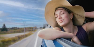 Route touristique Tour du lac Saint-Jean -  A woman in a moving car, window down, enjoying the wind