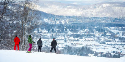 Four skiers at the summit of Sommet Olympia.