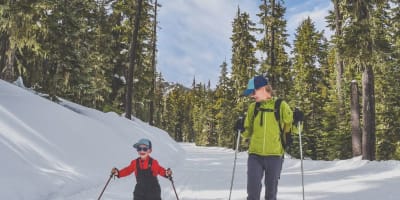 A mother and her young child doing cross-country skiing.