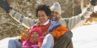 A happy family sliding down the snow.