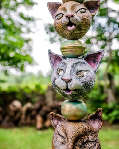 Centre d’Art Rozynski - A sculpture outdoors features a stack of cat heads separated by spheres.
