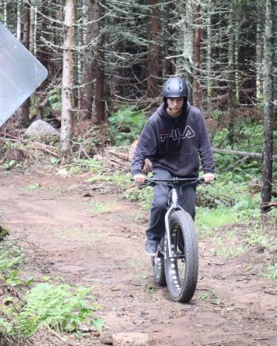 Centre récréotouristique des Hautes Terres - An individual riding a fatbike in a forest