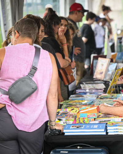 Festival de la BD de Prévost - Des bédéistes assis à des tables rencontrent des personnes