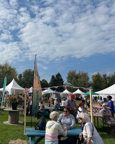 Festival des artisans de Sainte-Marcelline-de-Kildare - Un espace avec des tables de pique-nique et des chapiteaux blancs