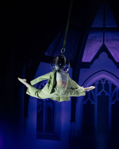 Le Monastère - Cabaret de Cirque - A suspended artist with their head in a disco ball