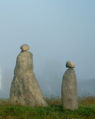 Les Amis du Patrimoine de Saint-Venant-de-Paquette - Deux sculptures en pierre, avec une église en arrière-plan
