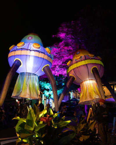 Lumifest Longueuil - Deux structures gonflables lumineuses en forme de vaisseaux spatiaux, entourées de spectateurs