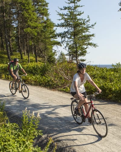 Parc national de la Pointe-Taillon - A man and a woman cycling in nature