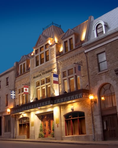 Façade de l'Hôtel Manoir Victoria en début de soirée.