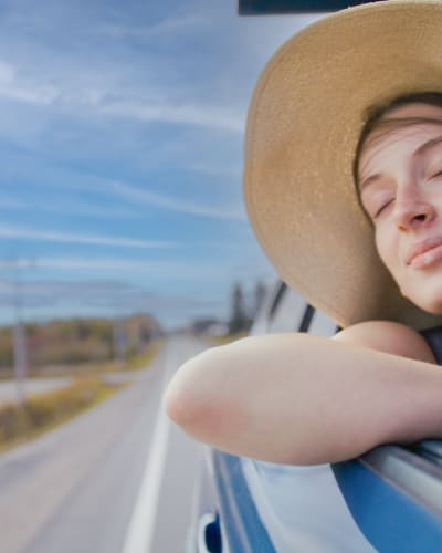 Route touristique Tour du lac Saint-Jean -  A woman in a moving car, window down, enjoying the wind