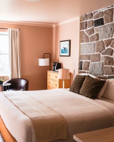 Pink room with a stone wall at Auberge La Rosepierre.