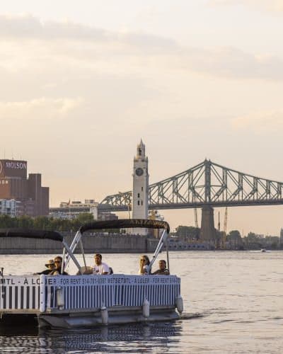 Friends are taking a cruise on the St. Lawrence River aboard an electric pontoon boat.