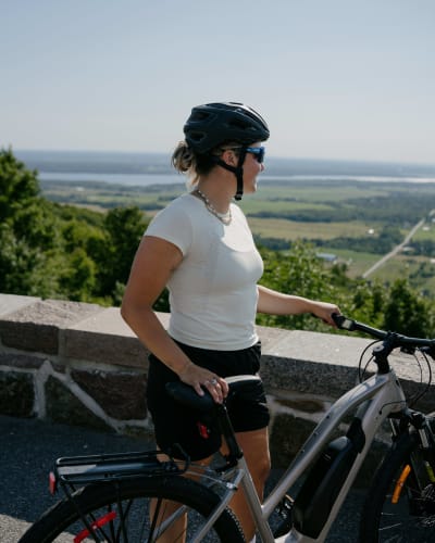 Femme cycliste au belvédère en été.