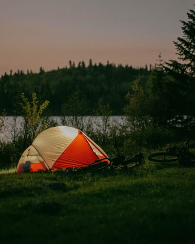 Une tente illuminée en soirée à la Réserve faunique des Laurentides.