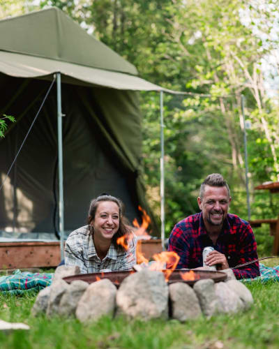 Couple devant un prêt-à-camper au Camping Sainte-Agathe-des-Monts au Parc régional Sainte-Agathe-des-Monts.