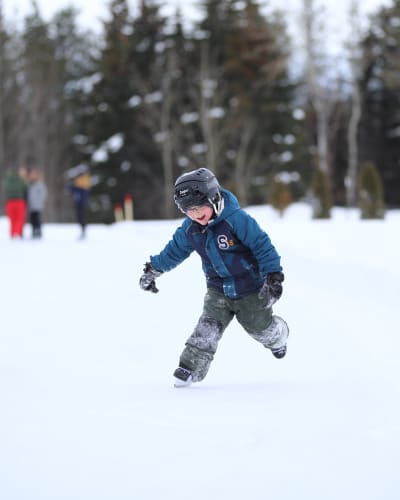 Two children are skating at the Dam-en-Terre Resort.
